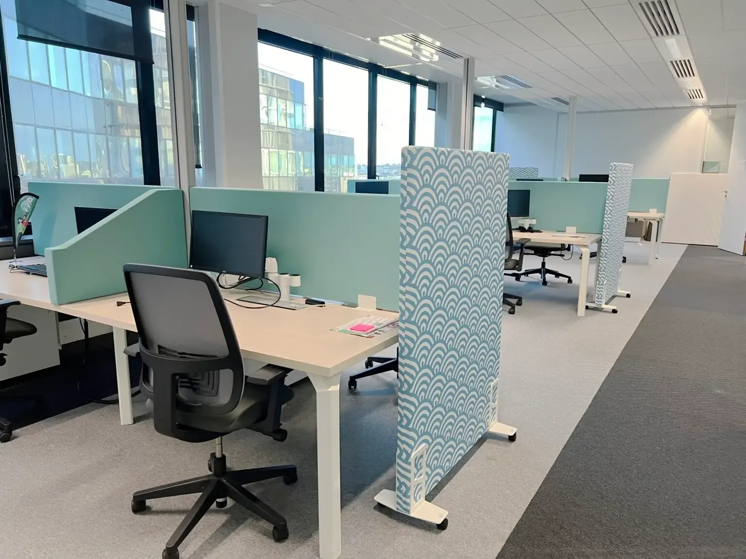 Open-space de bureau avant traitement acoustique, postes de travail rapprochés